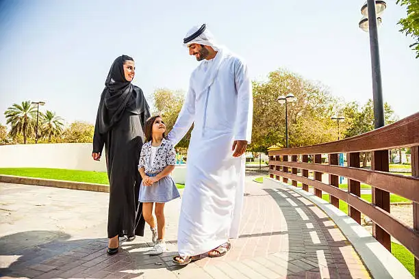 Family enjoying a park in Dubai Hills Estate with children playing