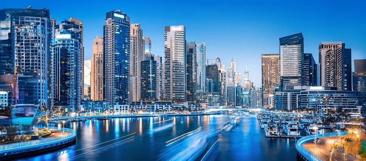 Split view of a Dubai commercial office tower and a residential waterfront community representing investment comparison