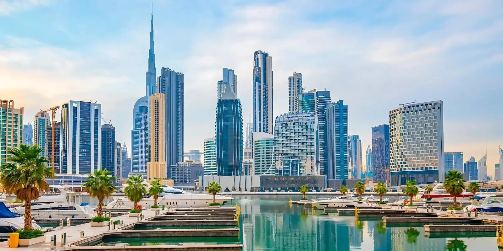 Dubai's magnificent skyline featuring Burj Khalifa, luxury towers, and marina with yachts reflecting in pristine waters